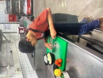 Ein Schüler schneidet Gemüse im Phantasialand Restaurant