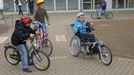 Foto: Schüler fahren mit den Handbikes im Schulhof